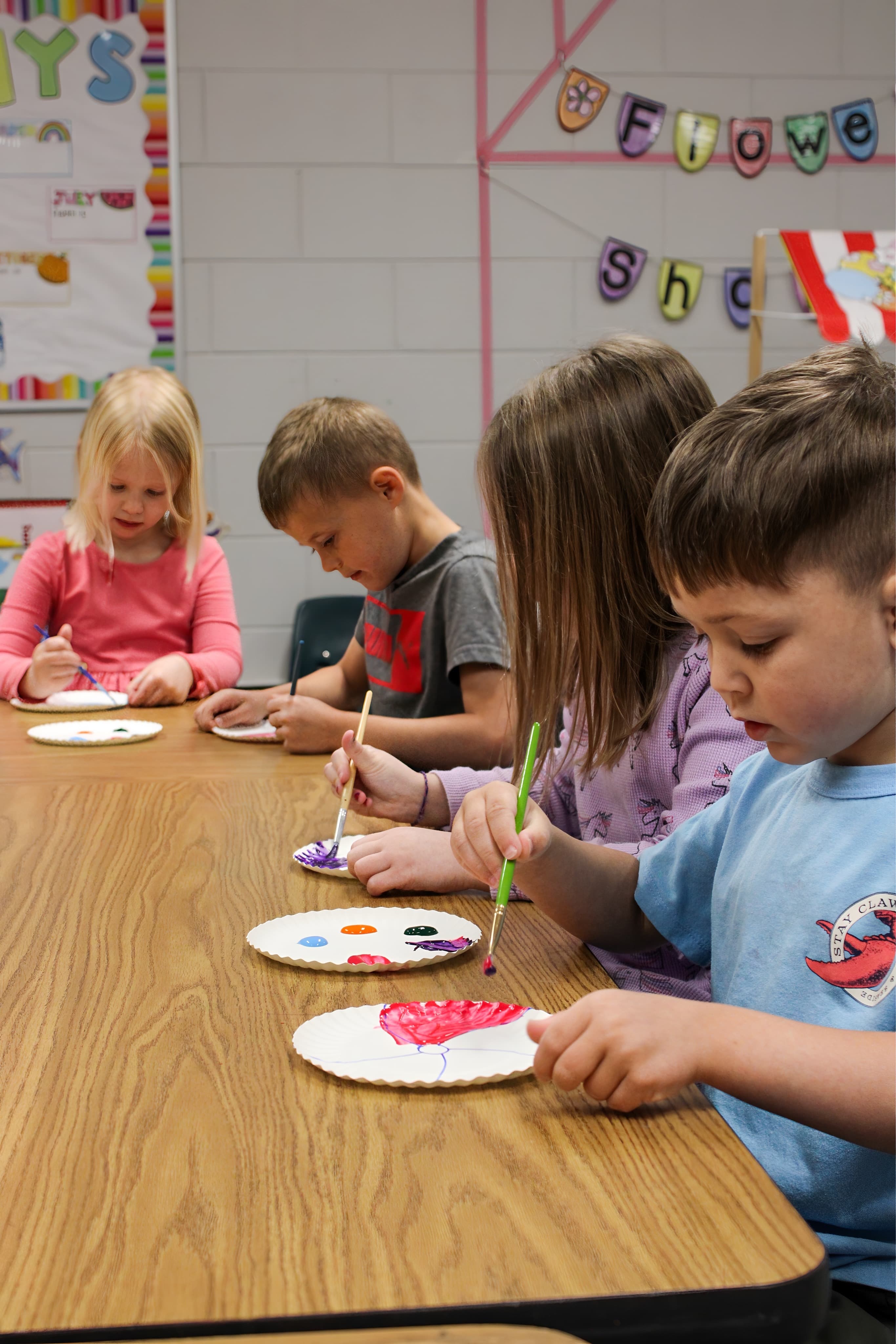 Preschoolers painting at a table